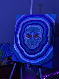 a blue and purple painting on a table in a dark room